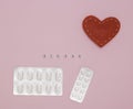 Concept of health, cardiology, heart disease. Words STROKE on white cubes, tablets in blisters on a pink background. Flat lay Royalty Free Stock Photo