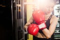 Concept of health-loving woman. Female boxer wearing red boxing gloves in fitness gym Royalty Free Stock Photo