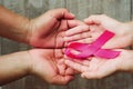 concept healthcare and medicine. hand holding pink ribbon on wood. breast cancer awareness. sign of hope Royalty Free Stock Photo