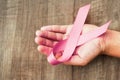 concept healthcare and medicine. hand holding pink ribbon on wood. breast cancer awareness. sign of hope Royalty Free Stock Photo