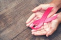 concept healthcare and medicine. hand holding pink ribbon on wood. breast cancer awareness. sign of hope Royalty Free Stock Photo