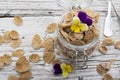 The concept of a healthy breakfast of whole wheat cereals, berries and edible flowers on a garden violet on a light Royalty Free Stock Photo