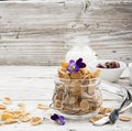 The concept of a healthy breakfast of whole wheat cereals, berries and edible flowers on a garden violet on a light Royalty Free Stock Photo