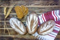 The concept of a healthy diet and a rich harvest of cereals. Three loaves of rye bread and pieces of sliced bread on a towel.