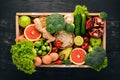 The concept of healthy food. Fresh vegetables, nuts and fruits in a wooden box. On a wooden background. Royalty Free Stock Photo