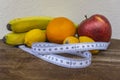 Concept of healthy food for loosing weight and good health - tape measure around pile of fruits Royalty Free Stock Photo