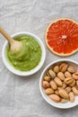 The concept of healthy food, pistachio paste, peeled and unpeeled salted pistachios, grapefruit, wooden spoon on a light Royalty Free Stock Photo