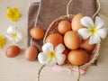 Concept healthy and happiness, Fresh brown chicken eggs in basket gift set decorated with white flowers on wooden table Royalty Free Stock Photo