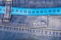 Concept of healthy lifestyle, weight loss. Jeans with measuring tape Royalty Free Stock Photo