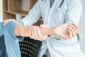 Concept healthy ,Male Patient in blue shirt visiting Doctor of Orthopedics examining injured arm of male patient in clinic Royalty Free Stock Photo