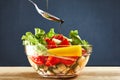 Concept healthy organic vegetarian meal,Pouring olive oil in the salad over a spoon Royalty Free Stock Photo