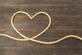 Concept of heart of the jute ropes, love, frame for greeting card on brown wooden background Royalty Free Stock Photo