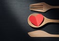 Concept, A heart is in a wooden spoon, fork and knife like some