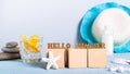 Concept hello summer text on cubes on cocktail background, sunblock and hat on table Royalty Free Stock Photo