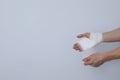 Concept of help during an injury, man wrapping hand in bandage on white background Royalty Free Stock Photo