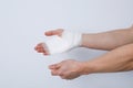 Concept of help during an injury, man wrapping hand in bandage on white background Royalty Free Stock Photo