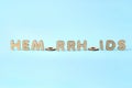 Concept of hemorrhoids with wooden letters on blue background