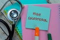 Concept of High Colesterol write on sticky notes with stethoscope isolated on Wooden Table Royalty Free Stock Photo