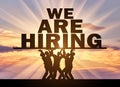 Concept of hiring. Silhouette of a group of people hold text ad, we are hiring