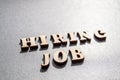 The concept of hiring workers, written by HIRING JOB in wooden letters on a gray background with selective focus and space for