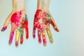 Concept of Holi, Indian festival of colors. Image of women`s hands on white background, close-up. Powdered paints on palms