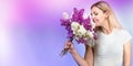 A beautiful young woman inhales the aroma of a spring bouquet of lilac. The concept of the holiday.