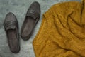 The concept of home comfort, coziness and warmth sweater and grey flat shoes on wood table Royalty Free Stock Photo