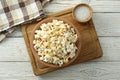 Concept of homemade salt popcorn on white wooden background