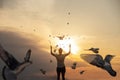 Concept of hope in the form of flying doves on the background of a sunny sunset