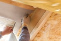 Worker cutting protective material near skylight window