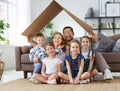 Concept of housing and relocation. happy  big family mother father and kids with roof at home Royalty Free Stock Photo
