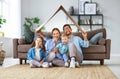 Concept of housing and relocation. happy family mother father and kids with roof at home Royalty Free Stock Photo