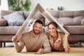 Concept housing  young family couple.  man and woman under fake roof in  new home Royalty Free Stock Photo