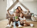 Concept housing  young family. mother father and children under fake roof in  new home Royalty Free Stock Photo