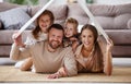 Concept housing  young family. mother father and children under fake roof in  new home Royalty Free Stock Photo