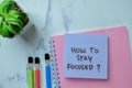 Concept of How To Stay Focused? write on sticky notes isolated on Wooden Table Royalty Free Stock Photo