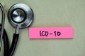 Concept of ICD-10 write on sticky notes with stethoscope isolated on Wooden Table Royalty Free Stock Photo