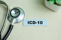 Concept of ICD-10 write on sticky notes with stethoscope isolated on Wooden Table Royalty Free Stock Photo