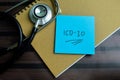 Concept of ICD-10 write on sticky notes with stethoscope isolated on Wooden Table Royalty Free Stock Photo