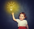 concept, the idea of a happy little girl with a bulb at the blackboard Royalty Free Stock Photo