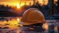 Close-up of a construction helmet on the background of a construction site and sunset. Royalty Free Stock Photo