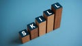 Skills word concept represented on wooden blocks arranged in ascending order indicating learning and growth on a bright blue Royalty Free Stock Photo