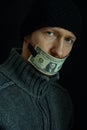 Concept image of corruption and bribery. Silent for money. Portrait of man with his mouth shut with one dollar banknote Royalty Free Stock Photo