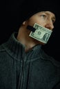 Concept image of corruption and bribery. Silent for money. Portrait of man with his mouth shut with one dollar banknote