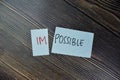Concept of Impossible to be possible write on sticky notes isolated on Wooden Table Royalty Free Stock Photo