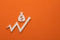 Money bag with upward arrow on orange background - Concept of increasing bank interest