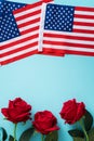 Concept of Independence day or Memorial day. American Flag over blue table background with red rose Royalty Free Stock Photo