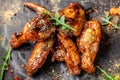 The concept of Indian cuisine. Baked chicken wings and legs in honey mustard sauce. Serving dishes in the restaurant on a black Royalty Free Stock Photo