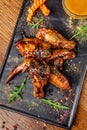 The concept of Indian cuisine. Baked chicken wings and legs in honey mustard sauce. Serving dishes in the restaurant on a black Royalty Free Stock Photo