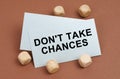 On a brown surface, wooden cubes and a business card with the inscription - Do not Take Chances